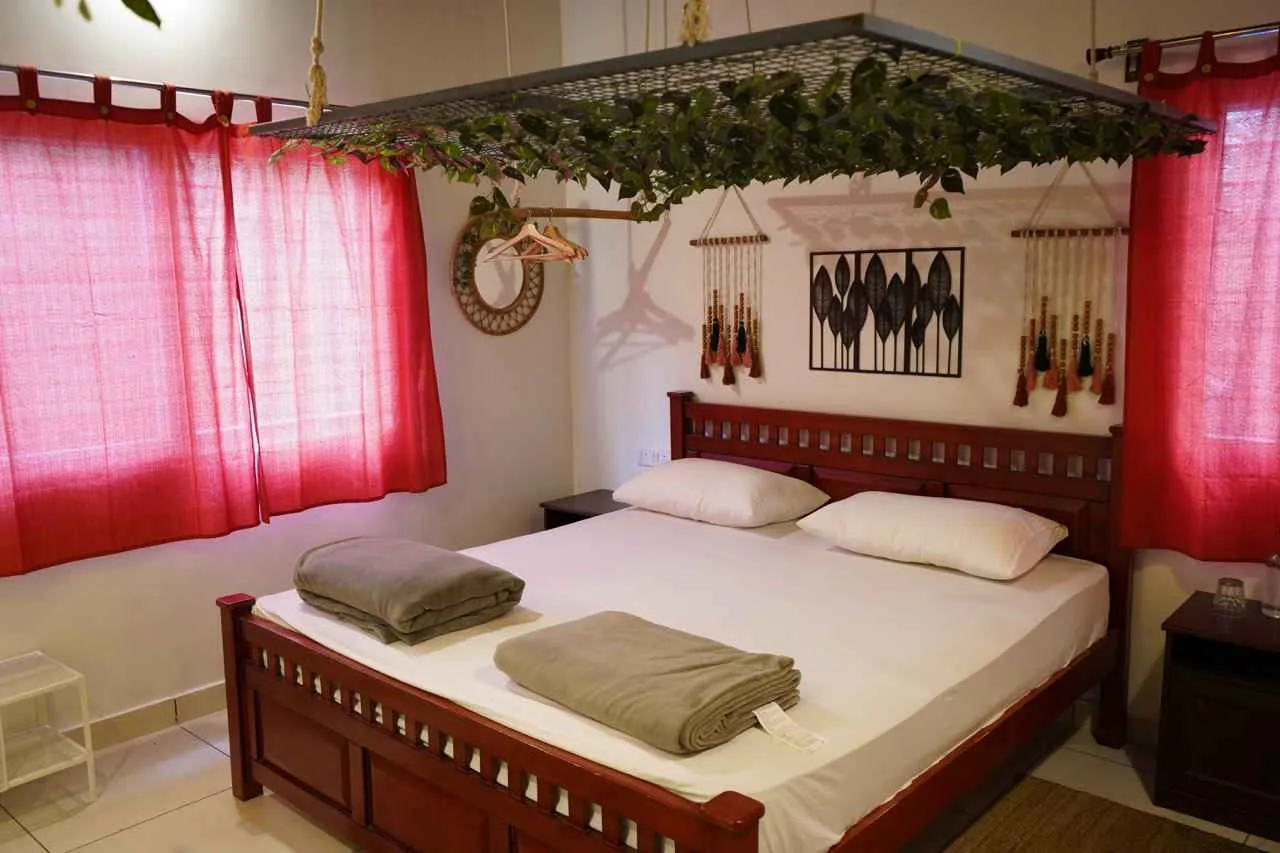 King room with leaf canopy and macramé wall art at Virama Farm Stay near Bangalore